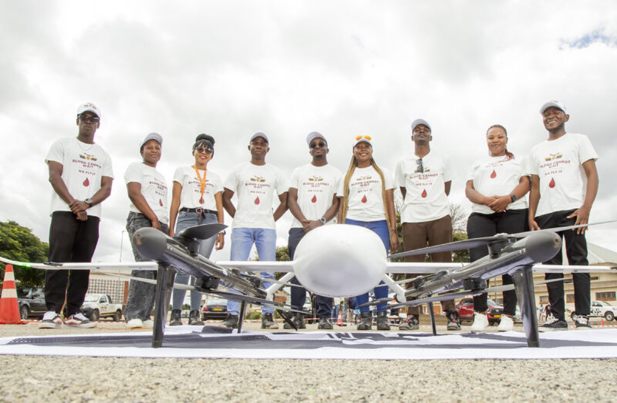 Medical delivery team standing behind a long-range delivery aircraft